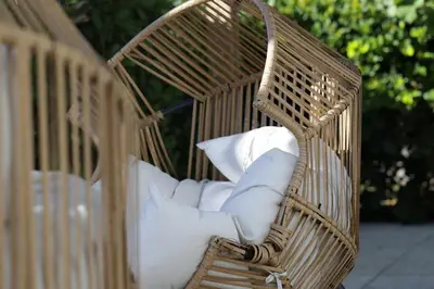 a wicker chair with white pillows in it at The Lemon Branch Hotel in Miami Beach