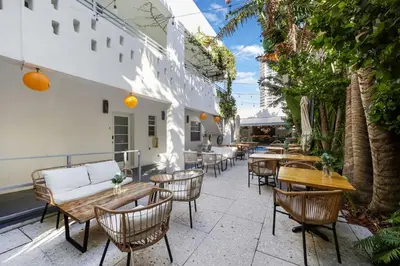 an outdoor seating area with tables and chairs at The Lemon Branch Hotel in Miami Beach