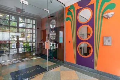 a hallway with an orange and purple wall with mirrors at Ocean Front Studio - Miami Beach in Miami Beach