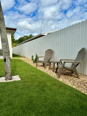 two benches sitting in a yard next to a fence at Oasis Yard -Pool-Jets-Game Room-BBQ-Relaxing in Carver Ranches