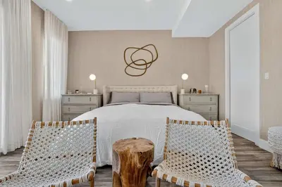 a bedroom with a bed and two chairs at Shoreline Villa by Rove - Rooftop & Beach Access in Hollywood