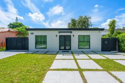 a white house with a fence and grass at Contemporary Family Oasis Pool and Comfort in Miami