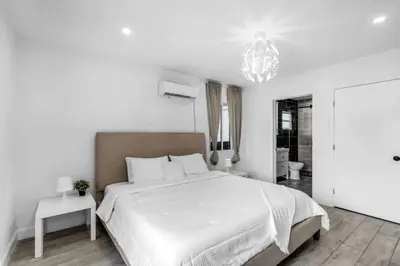 a white bedroom with a large bed and a chandelier at Contemporary Family Oasis Pool and Comfort in Miami