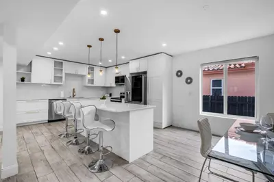 a kitchen with white cabinets and a table and chairs at Contemporary Family Oasis Pool and Comfort in Miami