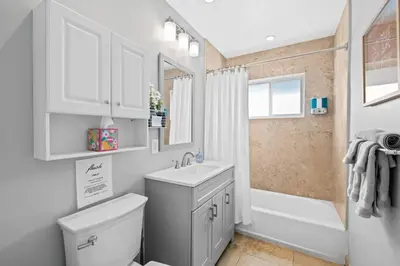 a bathroom with a sink and a toilet and a tub at 2 bed, steps from Wilton Drive, BBQ, fire pit in Fort Lauderdale