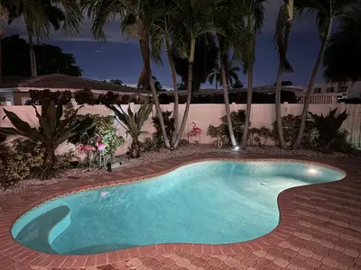 a small swimming pool in a yard with palm trees at Waterfront, Heated Pool, Game Room in Fort Lauderdale