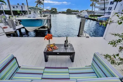 a table and chairs on a dock next to a boat at Waterfront, Heated Pool, Game Room in Fort Lauderdale