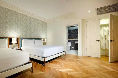 a white bedroom with a bed and a bathroom at Eurostars Langford in Miami