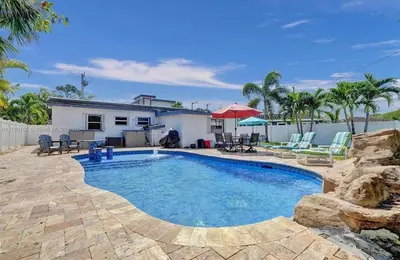 a swimming pool in front of a house at Aquaria in Fort Lauderdale
