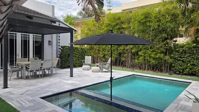 a swimming pool with an umbrella and a patio at Fun Location! 1 block to Las Olas Pool & Parking in Fort Lauderdale