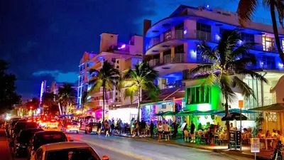 a busy city street at night with cars parked at Cozy 1BR Beach Apartment Walk to Miami Beach in Miami Beach