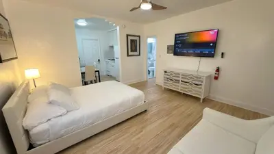 a bedroom with a white bed and a flat screen tv at Cozy 1BR Beach Apartment Walk to Miami Beach in Miami Beach