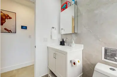 a white bathroom with a sink and a mirror at JS & JS 2040 LLC in Fort Lauderdale