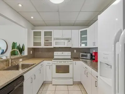 a kitchen with white cabinets and white appliances at Sea Air Towers - Oceanfront Condo w Pool & Gym in Hollywood