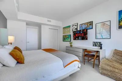 a bedroom with a bed and a desk and a chair at Lyfe Resort l Ocean Pool View Gym, Beach Access in Hollywood