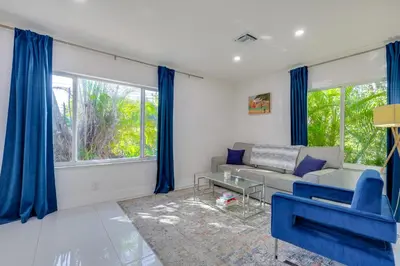 a living room with blue curtains and a blue couch at Couples Retreat 1 Mi to Fort Lauderdale Riverwalk in Fort Lauderdale