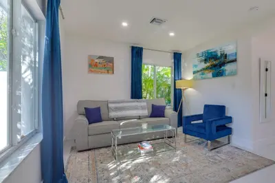 a living room with a couch and a blue chair at Couples Retreat 1 Mi to Fort Lauderdale Riverwalk in Fort Lauderdale