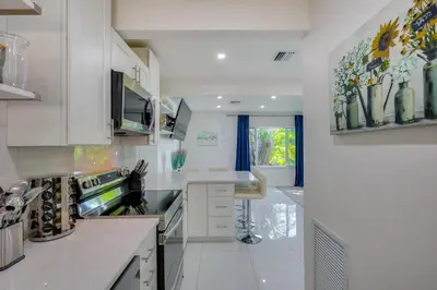 a kitchen with white cabinets and a large window at Couples Retreat 1 Mi to Fort Lauderdale Riverwalk in Fort Lauderdale
