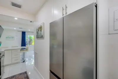 a pivot door in a bathroom with white walls at Couples Retreat 1 Mi to Fort Lauderdale Riverwalk in Fort Lauderdale