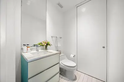 a white bathroom with a toilet and a sink at OceanView 1B Private Residence at South Beach - 514 in Miami Beach