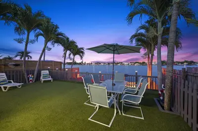 a patio with a table with chairs and an umbrella at Serene Lakefront Getaway Fishing & Kayaks in Fort Lauderdale