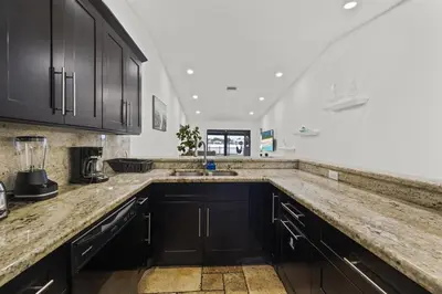a kitchen with black cabinets and a counter top at Serene Lakefront Getaway Fishing & Kayaks in Fort Lauderdale