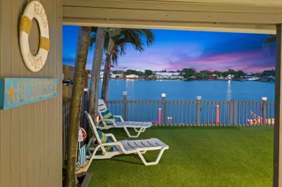 two chairs on a porch with a view of the water at Serene Lakefront Getaway Fishing & Kayaks in Fort Lauderdale