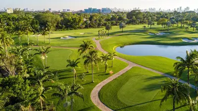 an aerial view of a golf course with palm trees and a pond at OceanView 1B Private Residence at South Beach - 1114 in Miami Beach