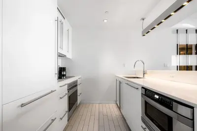 a white kitchen with white cabinets and a sink at OceanView 1B Private Residence at South Beach - 1114 in Miami Beach
