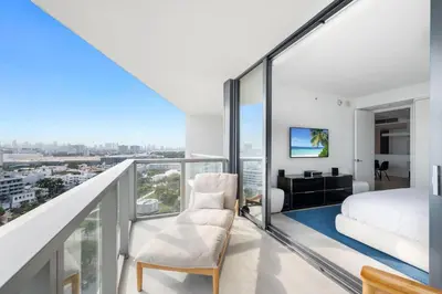 a bedroom with a balcony with a bed and a desk at OceanView 1B Private Residence at South Beach -1614 in Miami Beach