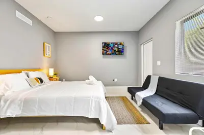 a bedroom with a large bed and a couch at Modern Studio in Wynwood Midtown in Miami