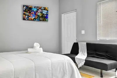 a bedroom with a bed and a couch and a painting at Modern Studio in Wynwood Midtown in Miami