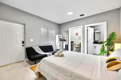a bedroom with a large bed and a couch at Modern Studio in Wynwood Midtown in Miami