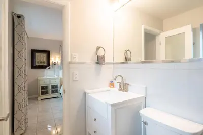 a white bathroom with a sink and a mirror at Wilton Manors Twin Oasis | 2 Heated Pools, For 12 in Fort Lauderdale