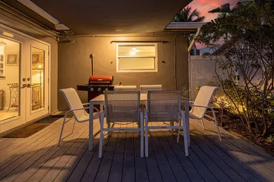 a table and chairs sitting on a deck at Wilton Manors Twin Oasis | 2 Heated Pools, For 12 in Fort Lauderdale