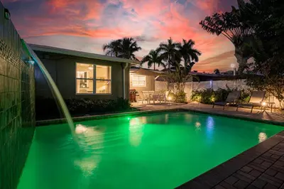 a swimming pool in front of a house at Wilton Manors 2BR Bungalow, Private Pool, Sleeps 6 in Fort Lauderdale