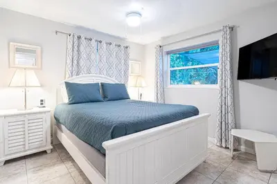 a white bedroom with a bed and a window at Wilton Manors 2BR Bungalow, Private Pool, Sleeps 6 in Fort Lauderdale