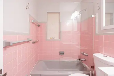 a pink bathroom with a tub and a toilet at Wilton Manors 2BR Bungalow, Private Pool, Sleeps 6 in Fort Lauderdale