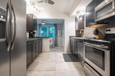 a kitchen with stainless steel appliances and brown cabinets at Wilton Manors 2BR Bungalow, Private Pool, Sleeps 6 in Fort Lauderdale