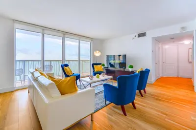 a living room with a white couch and blue chairs at Modern Waterfront Apartment with Brickell City Views in Miami