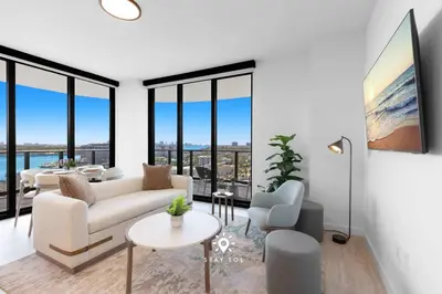 a living room with white furniture and large windows at Chic 2BR Apartment Gym & Balcony Views in Miami Beach