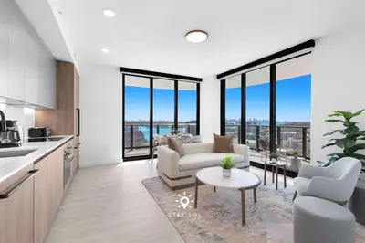 a kitchen and living room with a couch and a table at Chic 2BR Apartment Gym & Balcony Views in Miami Beach