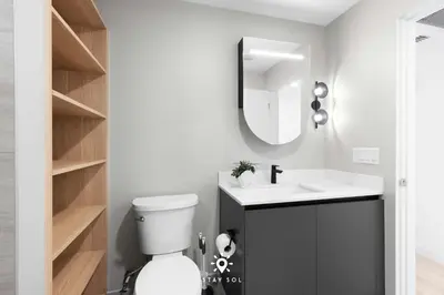 a bathroom with a toilet and a sink and a mirror at Beautiful Apt -Private Balcony & Pool in Miami Beach