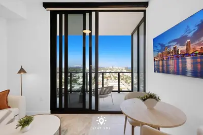 a living room with a large window with a view at Coastal Apartment - Pool & Breezy Balcony in Miami Beach