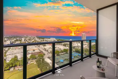 a room with a view of the ocean and a city at Coastal Apartment - Pool & Breezy Balcony in Miami Beach