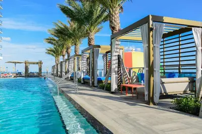 a resort with a pool and palm trees at Lyfe Resort & Residences in Hollywood
