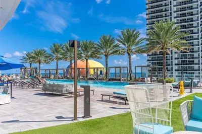 a swimming pool with palm trees and a building at Ocean Luxe Pad for 6 Guests with Poolside Access in Hollywood