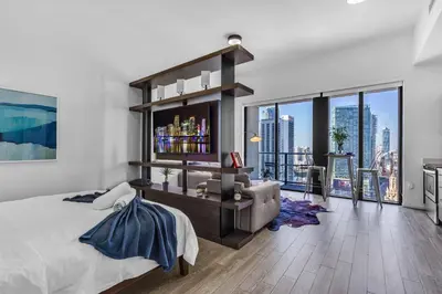 a bedroom with a large bed and a large window at Downtown Luxe Studio Miami Skyline Retreat in Miami