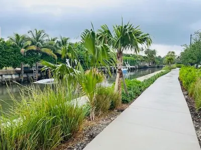 a walking path next to a river with palm trees at South Beach Paradise Jr Suite next to Convention Center in Miami Beach