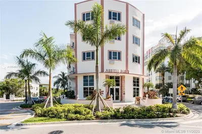 a tall pink building with palm trees in front of it at South Beach Paradise Jr Suite next to Convention Center in Miami Beach